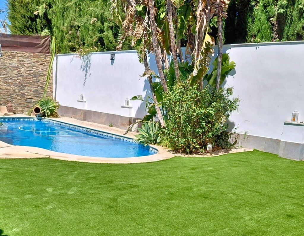 jardín en verano con césped artificial 